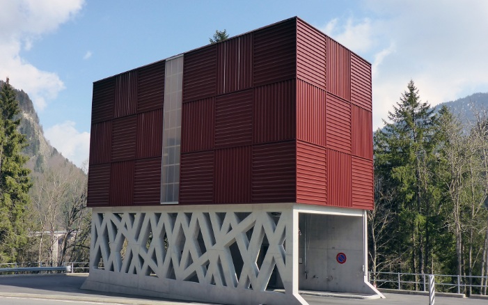 red architectural module silo with filigree concrete substructure whereby a road leads through
